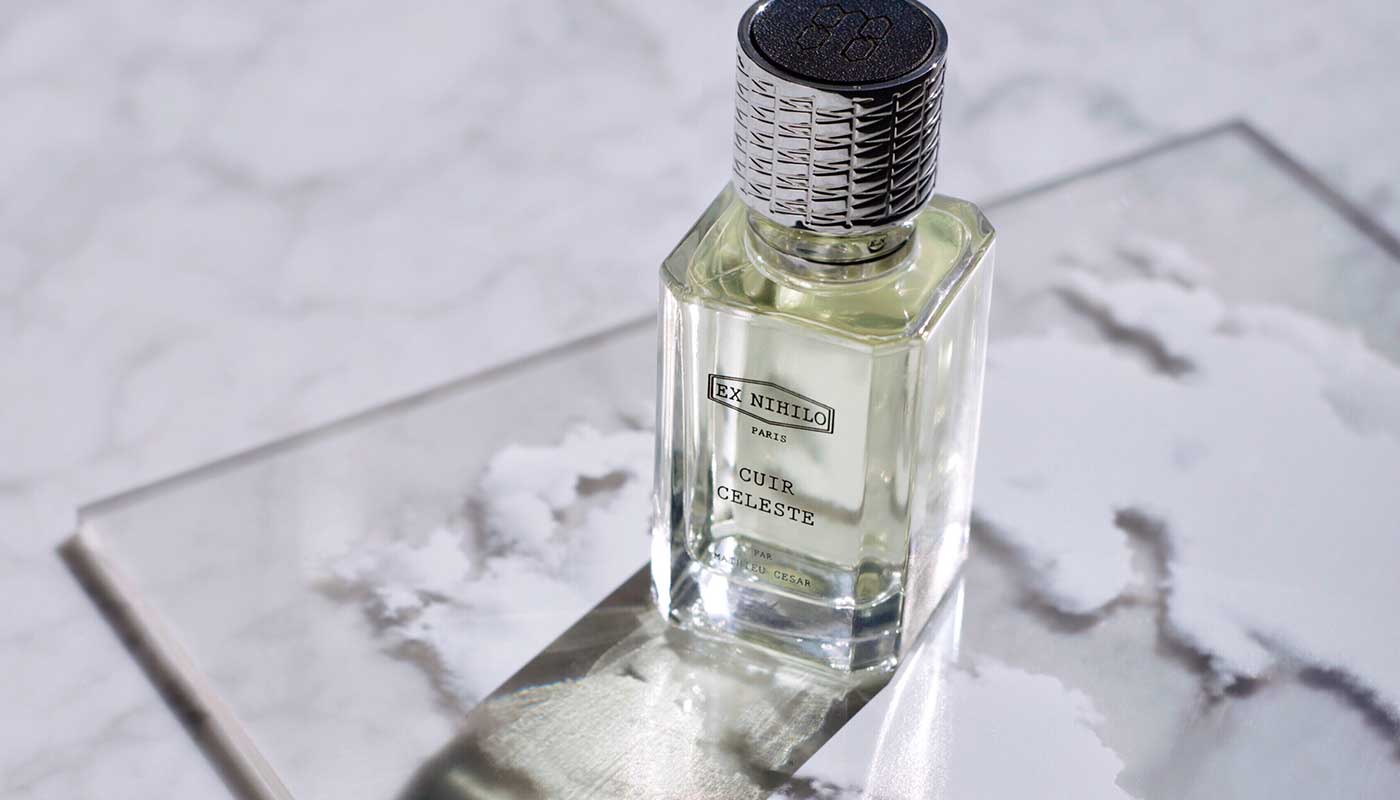 Cuir Celeste perfume bottle casting a shadow on a marble countertop
